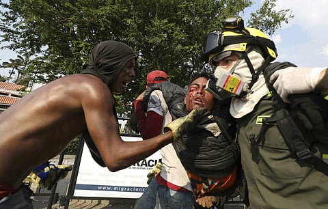 A Venezuelan youth, injured in clashes with Venezuelan National Guardsmen, is carried to a safe zone, at the Simon Bolivar International Bridge in La Parada, Colombia, Monday, Feb. 25, 2019. (Photo | AP)