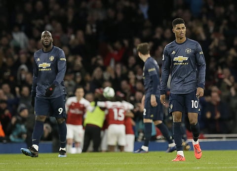 Manchester United's Marcus Rashford, right, and Manchester United's Romelu Lukaku, left, walk on the pitch in dejection after Arsenal's Pierre-Emerick Aubameyang scored his side's second goal during the English Premier League soccer match between Arsenal