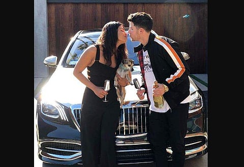 Priyanka Chopra and Nick Jonas kiss in front of the latter's gift to his wife, a luxury black Maybach car. (Photo | Priyanka Chopra Twitter)
