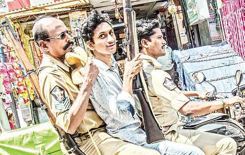 An undertrial carrying the gun of one of the policemen on their way to court in Vijayawada on Thursday. This undoubtedly raises questions about the preparedness of the police department to deal with law and order issues during this crucial election time |