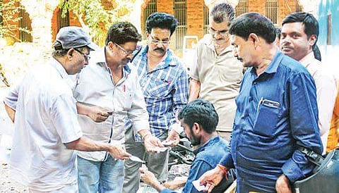 A volunteer helping people at the helpline centre in the Collectorate in Vizag on Thursday to verify their names in the voter list | Express