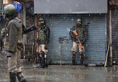 Indian paramilitary soldiers take shelter near closed shops as it rains during a strike in Srinagar, Wednesday, March 20, 2019. | AP