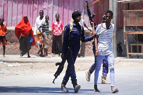 Somali soldiers arrest a civilian close to the scene of two explosions set off near the ministries of public works and labour in Mogadishu. (AFP photo)