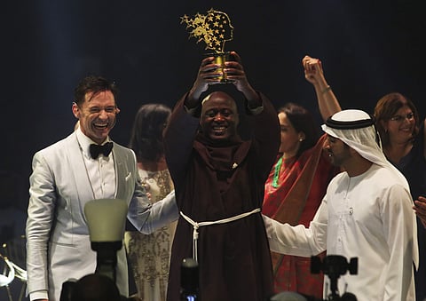 Kenyan teacher Peter Tabichi, center, actor Hugh Jackman, left, and Dubai crown prince Sheikh Hamdan bin Mohammed Al Maktoum, right, react after Tabichi won the $1 million Global Teacher Prize in Dubai, United Arab Emirates. (Photo | AP)