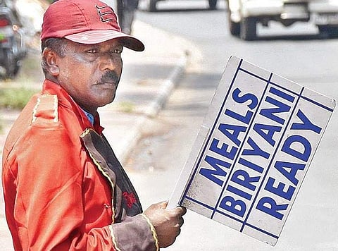 Hotel staff standing in the sun bearing placards. |BP Deepu