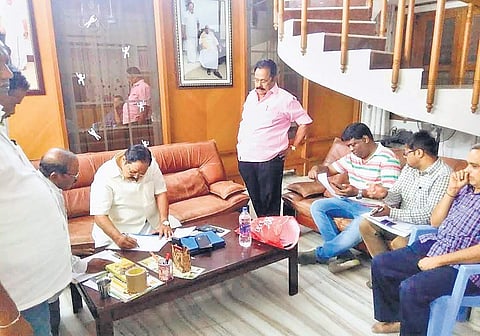 DMK treasurer Durai Murugan examining the papers, the Income Tax officials produced during an attempt to raid his house, in Katpadi on Friday night | Express