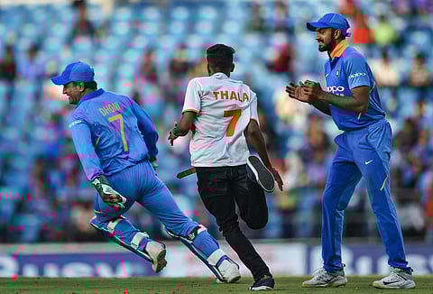 MS Dhoni runs away from a pitch-invader during the 2nd ODI cricket match against Australia at Vidarbha Cricket Association Stadium in Nagpur. (Photo | PTI)