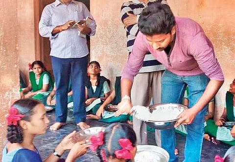 Devideni Naga Satheesh serves food to government school students in Managlagiri on Tuesday as part punishment for traffic rule violation