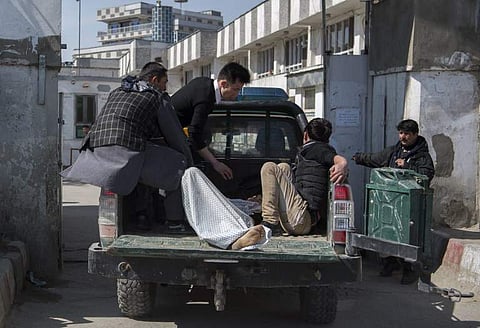 Afghan volunteers transport a victim on a police vehicle to Isteqlal Hospital following the blasts. (AFP photo)