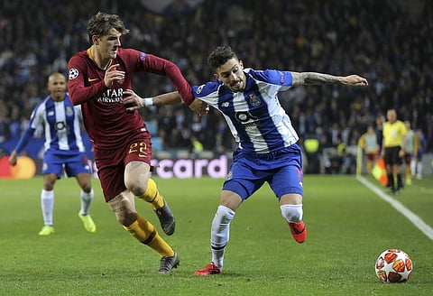 Roma midfielder Nicolo' Zaniolo fights for the ball with Porto defender Alex Telles, right, during the Champions League round of 16, 2nd leg, soccer match between FC Porto and AS Roma at the Dragao stadium in Porto, Portugal, Wednesday, March 6, 2019. | A