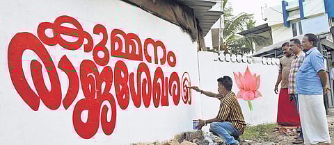 BJP workers wasted no time to paint poll graffito after news came in about Mizoram Governor Kummanam Rajasekharan’s resignation (Photo | BP Deepu/EPS)