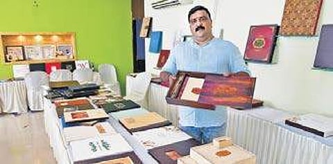 Praveen of Indot Photo Work with a customised album. The album comes in a wooden box and has photos printed on wood, paper, canvas and jute Albin Mathew