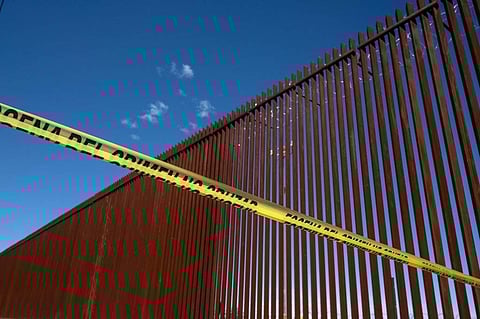 A police line marks a security perimeter near the US-Mexico border fence. (Photo | AFP)