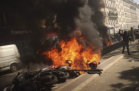 A set of motorbikes are set alight during a yellow vest demonstration in Paris, Saturday, April 20, 2019. French yellow vest protesters are marching anew to remind the government that rebuilding the fire-ravaged Notre Dame Cathedral isn't the only problem