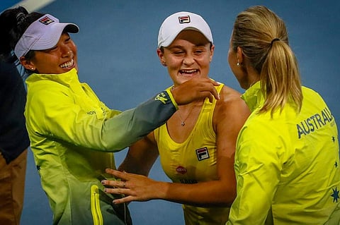 Ashleigh Barty (C) is embraced by Priscilla Hon (L) and Australian Captain Alicia Molik following their third round doubles victory of the Fed Cup tennis semi-final between Australia and Belarus. (Photo | AFP)