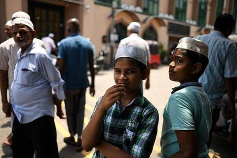 Muslims gather outside a mosque after prayers in Colombo. (Photo | AFP)