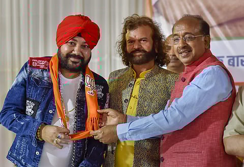 Singer Daler Mehndi joins the BJP party in the presence of senior party leader Vijay Goel and Lok Sabha candidate from North-West Delhi constituency Hans Raj Hans at BJP office in New Delhi. (Photo | PTI)