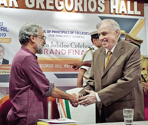 KSHEC Vice Chairman P M Rajan Gurukkal wishes Justice P Sathasivam on his 70th birthday, at the venue of the golden jubilee celebrations of the council of principals of colleges in Kerala held at Mar Ivanios College | express
