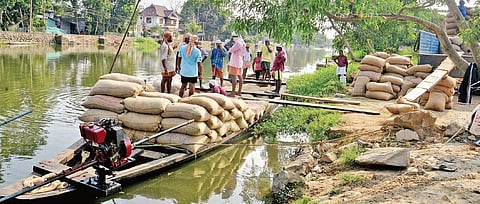 Farmers and headload workers unloading the paddy sacks from a country boat near Ramankary jetty in Kuttanad. The paddy farmers in the region have reaped a bumper paddy harvest owing to the floods which brought fertile alluvial soil along with its course |
