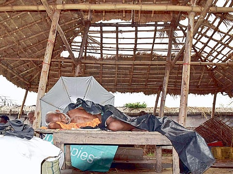 An elderly man takes a nap under a damaged hut in Cuttack on Thursday I Rashmiranjan Mohapatra