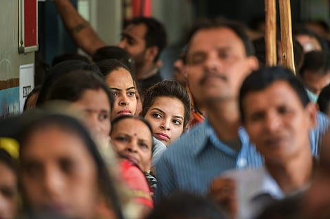 Voters wait in queues to cast their votes at Sangam Vihar polling station for the sixth phase of Lok Sabha polls in New Delhi Sunday. (Photo | PTI)