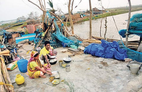 A couple taking food outside their broken hut at Sipakuda near Satapada in Puri district I Biswanath Swain
