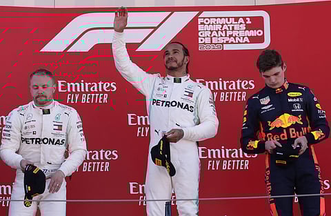 Mercedes driver Lewis Hamilton of Britain, center, celebrates on the podium after winning the Spanish Formula One race, flanked by second place Mercedes driver Valtteri Bottas of Finland, left and third place Red Bull driver Max Verstappen of the Netherla