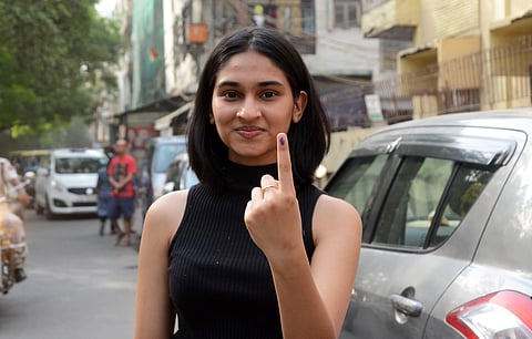 A first-time voter shows her finger with an indelible ink mark after casting her vote at a polling station at Rajinder Nagar in New Delhi. Image used for representation