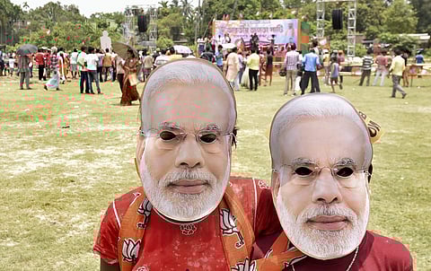 BJP supporters wearing mask of Prime Minister Narendra Modi at an election rally. (Photo | PTI)