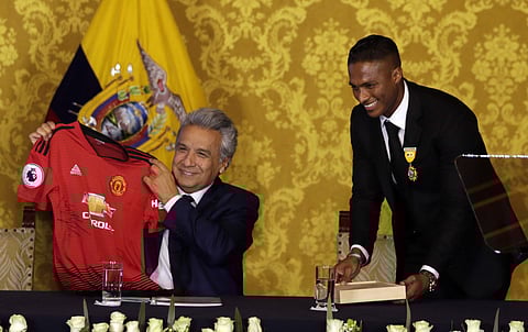 Ecuador's President Lenin Moreno holds up a Manchester United jersey delivered by the just retired soccer player Antonio Valencia | AP