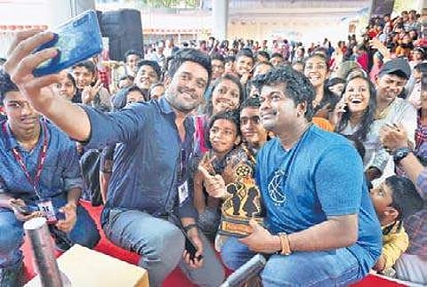 Musician Stephen Devassy who spoke at 'Meet the Artist' session, takes a selfie with the children at the ICFFK (Photo | Nandakumar HV/EPS)