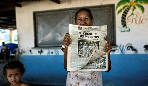 A woman shows a 2012 publication of a local newspaper carrying the story of the 1967 Cuban guerrilla operation in Machurucuto, Venezuela. (File Photo | AP)