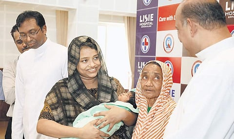 Jamsheela, along with her eight-day-old infant who successfully underwent the first phase of cardiac treatment at Lisie Hospital, with the doctors after the press conference at the hospital on Thursday (Photo | Arun Angela)