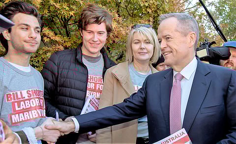 Australian Labor Party leader Bill Shorten, right, shakes hands with supporters at a polling station for a federal election in Melbourne. (Photo | AP)