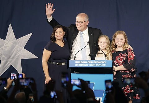 Australian Prime Minister Scott Morrison, second left, arrives on stage to speak to party supporters flanked by his wife, Jenny, left, and daughters Lily, and Abbey, right, after his opponent concedes in the federal election in Sydney, Australia, Sunday,