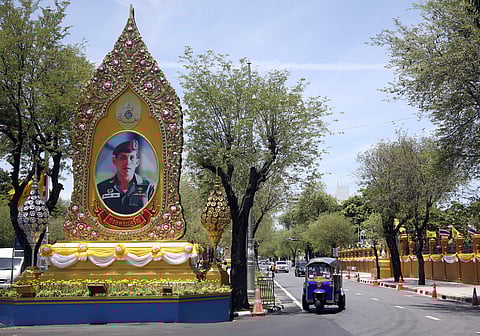 A three-wheel drives beside a giant portrait of Thailand's King Maha Vajiralongkorn Bodindradebayavarangkun in Bangkok (Photo | AP)