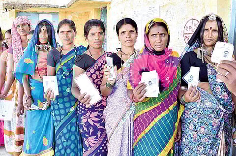 Lambani women stand in queue to exercise their franchise at a polling booth in Chincholi taluk on Sunday | express