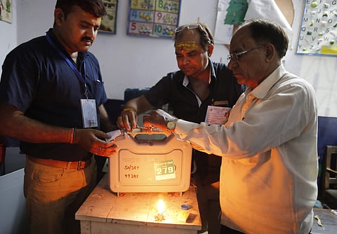 Election officers seal an EVM at the end of polling in Varanasi on Sunday. (File Photo | AP)