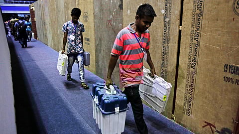 Workers carry Electronic Voting Machines to a distribution center. (Photo | AP)