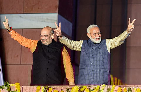 Prime Minister Narendra Modi flashes the victory sign along with party president Amit Shah as they arrive at the party headquarters to celebrate their victory in the 2019 Lok Sabha elections in New Delhi on 23 May 2019. (Photo | PTI)