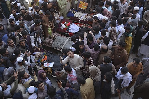 Afghan people stand over bodies of civilians during a protest in Nangarhar province east of Kabul. (Photo | AP)