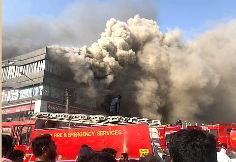 Smoke billows from the Taxshila Complex after a fire engulfed the third and fourth floor of the coaching centre in Surat Friday May 24 2019. | PTI