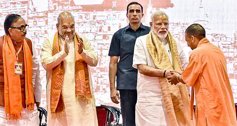 Prime Minister Narendra Modi being felicitated by UP CM Yogi Adityanath as BJP President Amit Shah and party's UP chief Mahendra Nath Pandey look on during a meeting with the party workers at Deen Dayal Upadhyay Hastkala Sankul in Varanasi Monday May 27 2