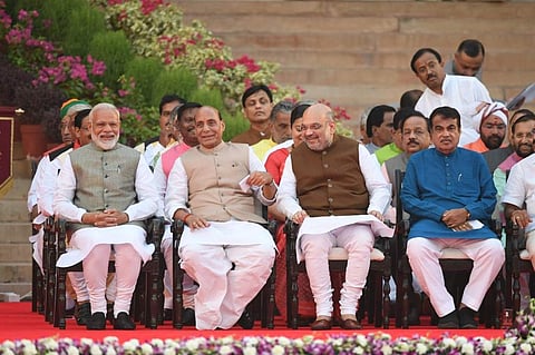 Narendra Modi (L) looks on as he sits next to Bharatiya Janata Party President Amit Shah (2R) and Minister of Home Affairs of India Rajnath Singh (2L) before Modi's swearing-in ceremony as Indian Prime Minister at the President house in New Delhi on Thurs