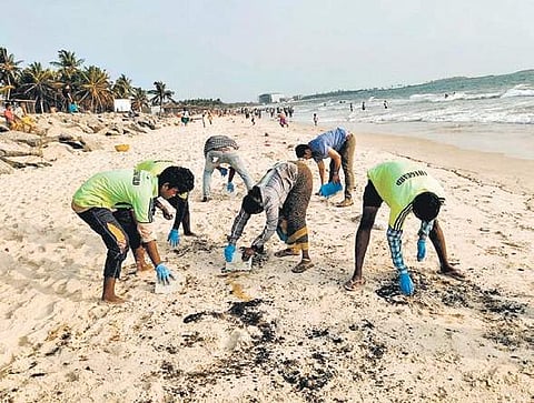 Volunteers cleaning the oil spill at Malpe beach, on Wednesday I Express