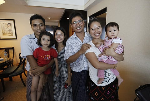Reuters journalist Kyaw Soe Oo, left, holds his daughter next to wife Chit Su Win, and Reuters journalist Wa Lone poses with wife Pan Ei Mon and daughter after being released from prison after receiving a presidential pardon in Yangon, Myanmar on Tuesday.