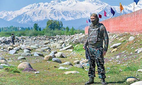 Security personnel stand guard near a polling station during the fifth phase of Lok Sabha elections, in Pulwama district, on Monday | Pti