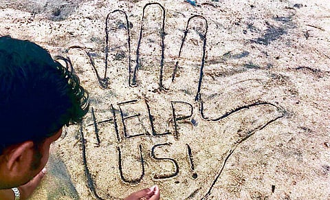 Sand sculptor Sudarsan Pattnaik appeals to people to come together to rebuild cyclone ravaged Odisha through his sand art in Puri on Tuesday| Express