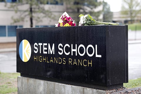 Bouquets of flowers sit on the sign outside the STEM School Highlands Ranch late Wednesday, May 8, 2019, in Highlands Ranch, Colorado. (Photo | AP)