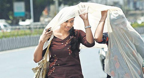 two women cover themselves with a dupatta to beat the heat | Ashwin Prasath